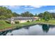 Scenic view of backyard featuring lush green lawn, mature trees, and waterfront views at 900 Maclaren N Dr # D, Palm Harbor, FL 34684