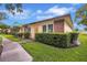 Charming single-story home with manicured lawn, lush greenery, and brick accents at 900 Maclaren N Dr # D, Palm Harbor, FL 34684