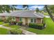 Charming villa with brick accents, lush landscaping, and a serene view of the adjacent pond at 900 Maclaren N Dr # D, Palm Harbor, FL 34684