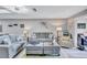 Bright living room featuring gray sofas, modern lighting, and light gray floors at 900 Maclaren N Dr # D, Palm Harbor, FL 34684
