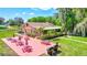 View of the picnic area with red picnic tables and lush landscaping near the clubhouse at 900 Maclaren N Dr # D, Palm Harbor, FL 34684