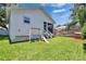 Backyard features green lawn, play area with a swing and a slide, screened-in porch, and white wood siding at 910 E Crenshaw St, Tampa, FL 33604