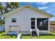 Backyard with a screened in porch, and play area featuring a swing and a slide at 910 E Crenshaw St, Tampa, FL 33604