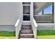 Backyard with stairs leading to the screened porch and well-maintained lawn at 910 E Crenshaw St, Tampa, FL 33604