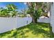 Fully fenced backyard with a white privacy fence and mature shade tree at 910 E Crenshaw St, Tampa, FL 33604