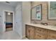 This bathroom features a dual sink vanity with wooden cabinets and a view into the Primary bedroom at 910 E Crenshaw St, Tampa, FL 33604