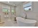 This bathroom boasts a soaking tub, a glass-enclosed shower, and a window with natural lighting at 910 E Crenshaw St, Tampa, FL 33604