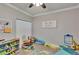 Bright bedroom featuring a ceiling fan, carpet floors and a PLAY all day sign at 910 E Crenshaw St, Tampa, FL 33604