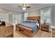 This bedroom features a wooden bed frame, dresser, ceiling fan, and an ensuite bathroom with a tub at 910 E Crenshaw St, Tampa, FL 33604
