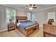 This bedroom is bright and spacious, featuring a wooden bed frame, two windows, and soft neutral carpeting at 910 E Crenshaw St, Tampa, FL 33604