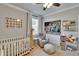 Bright bedroom with a crib, a chair, a window and a closet at 910 E Crenshaw St, Tampa, FL 33604