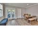 Dining area featuring a wooden table, bench, and a blue ottoman near the window at 910 E Crenshaw St, Tampa, FL 33604