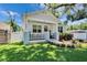 Beautifully landscaped front yard with a charming white home, complete with a cozy front porch at 910 E Crenshaw St, Tampa, FL 33604