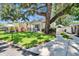 Well-maintained home with lush landscaping, a big tree, and a side driveway for parking convenience at 910 E Crenshaw St, Tampa, FL 33604