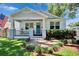 Charming single-Gathering home with a welcoming front porch, blue front door and well-manicured landscaping at 910 E Crenshaw St, Tampa, FL 33604