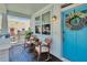 Inviting front porch with rocking chairs, charming wreath on a turquoise blue door at 910 E Crenshaw St, Tampa, FL 33604