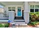 Charming home featuring front porch with blue door and lovely wreath at 910 E Crenshaw St, Tampa, FL 33604