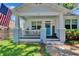 Charming front porch of a two story home featuring a blue door and front yard at 910 E Crenshaw St, Tampa, FL 33604
