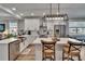 Contemporary kitchen with white cabinetry, stainless steel appliances, island seating, and stylish pendant lighting at 910 E Crenshaw St, Tampa, FL 33604