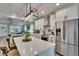 Modern kitchen featuring stainless steel appliances, white cabinets, and open sightlines to living area at 910 E Crenshaw St, Tampa, FL 33604