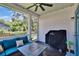 Relaxing screened porch features dark wood floors, fan, and a cozy seating area at 910 E Crenshaw St, Tampa, FL 33604
