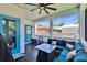 Charming porch with dark wood floors, fan, blue door, and comfortable seating area at 910 E Crenshaw St, Tampa, FL 33604