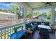 Screened porch with dark wood floors, fan, and comfortable seating arrangement at 910 E Crenshaw St, Tampa, FL 33604