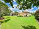 Expansive backyard with lush green lawn, gazebo, mature trees and screened in patio at 9951 121St St, Seminole, FL 33772