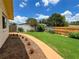 Well-maintained backyard featuring green grass, flowers, mulch, and a bright blue sky at 9951 121St St, Seminole, FL 33772