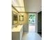 Bright bathroom with white vanity, modern fixtures, and a door to the outdoor area at 9951 121St St, Seminole, FL 33772