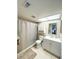 Bright bathroom featuring a shower-tub combo, toilet, vanity with sink, and storage cabinet at 9951 121St St, Seminole, FL 33772