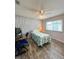Bedroom with grey walls, wood-look floors, ceiling fan, and a large window at 9951 121St St, Seminole, FL 33772
