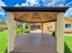 View from inside the gazebo to the house and backyard featuring well-manicured lawn at 9951 121St St, Seminole, FL 33772
