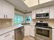 Modern kitchen with stone countertops and stainless steel appliances overlooking backyard at 9951 121St St, Seminole, FL 33772