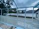 Backyard with white fence, gate to lawn, and screened enclosure offers privacy and outdoor space at 10444 Fordham St, Spring Hill, FL 34608