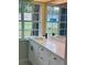 Bathroom with white cabinets, granite countertops, and a large window at 10444 Fordham St, Spring Hill, FL 34608
