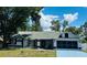 Charming single-story home with a well-manicured lawn, attached garage, and mature trees at 10444 Fordham St, Spring Hill, FL 34608