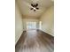 Spacious living room with wood floors, fan, and sliding glass doors to pool at 10444 Fordham St, Spring Hill, FL 34608