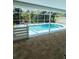 View of a screened in swimming pool with light blue trim and white privacy fence at 10444 Fordham St, Spring Hill, FL 34608