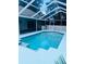 Sparkling swimming pool surrounded by a screened enclosure and lush greenery at 10444 Fordham St, Spring Hill, FL 34608