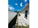 Side yard featuring a paved pathway, white fence, and manicured landscaping at 10444 Fordham St, Spring Hill, FL 34608