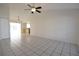Open-concept living space with light tile flooring, vaulted ceilings, and a ceiling fan at 10921 Brightside Dr, Tampa, FL 33624
