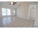 Well-lit living room featuring tile flooring, a large window, and an entryway with a white front door at 10921 Brightside Dr, Tampa, FL 33624