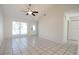 Bright living room with tile flooring, vaulted ceilings, and natural light from the large window at 10921 Brightside Dr, Tampa, FL 33624