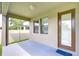 Back patio with gray flooring and view of neighboring house and green grass at 11011 Little Blue Heron Dr, Riverview, FL 33579