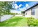 Fenced backyard featuring a lush green lawn and a covered patio, ideal for outdoor entertaining at 11011 Little Blue Heron Dr, Riverview, FL 33579