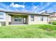 The exterior of the backyard features grass and a concrete patio and roofing repair work at 11011 Little Blue Heron Dr, Riverview, FL 33579