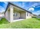 Exterior of backyard features covered patio with grassy lawn and clear blue skies above at 11011 Little Blue Heron Dr, Riverview, FL 33579