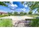 A neighborhood basketball court is surrounded by mature trees, lush landscaping, and park benches at 11011 Little Blue Heron Dr, Riverview, FL 33579