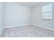 This is a bedroom with light grey walls and trim, carpeted floors and one window at 11011 Little Blue Heron Dr, Riverview, FL 33579